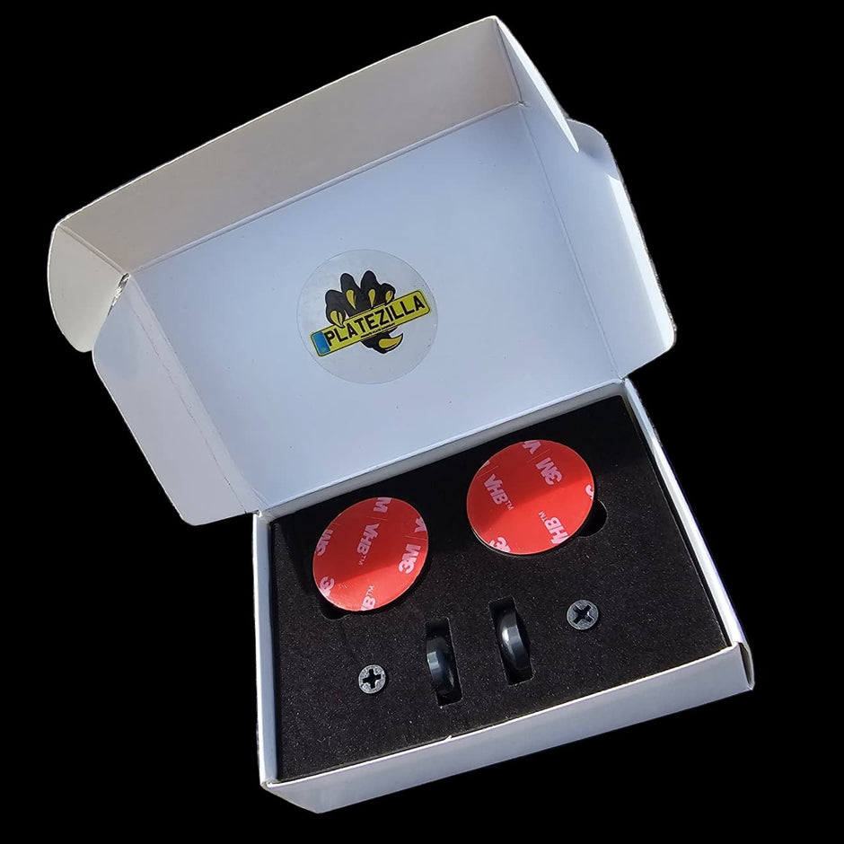 Red circular objects with black centers in a white box on a textured surface